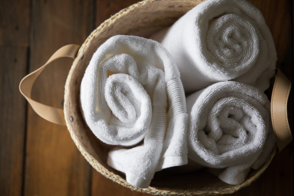 Pegs and basket of white towels in laundry