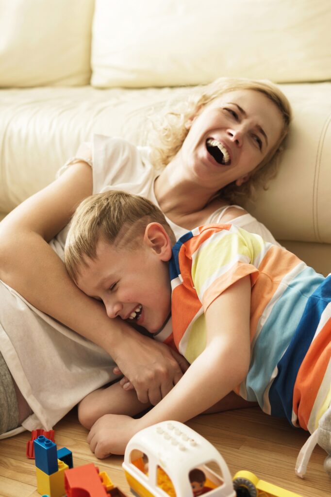 Laughing mother and son playing at home