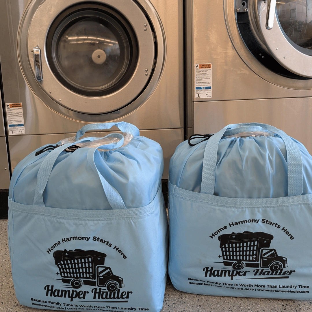 Hamper Hauler laundry bags in front of professional industrial washing machines.